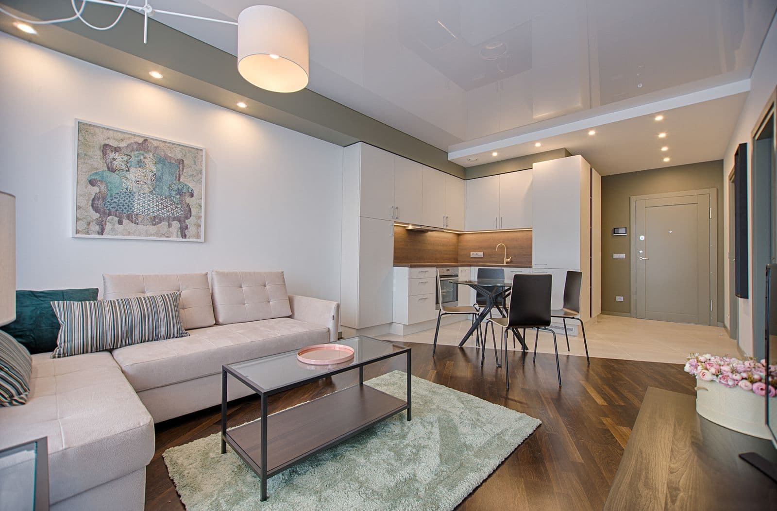 Living room with a beige sectional sofa and open kitchen